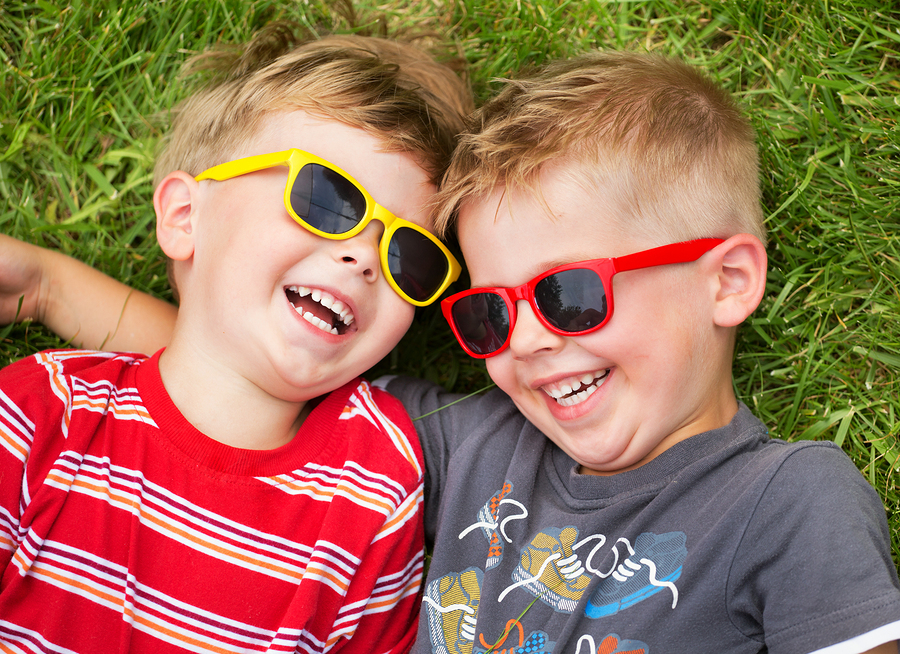 toddler boys laying in grass laughing, Beeville, TX pediatric dentistry